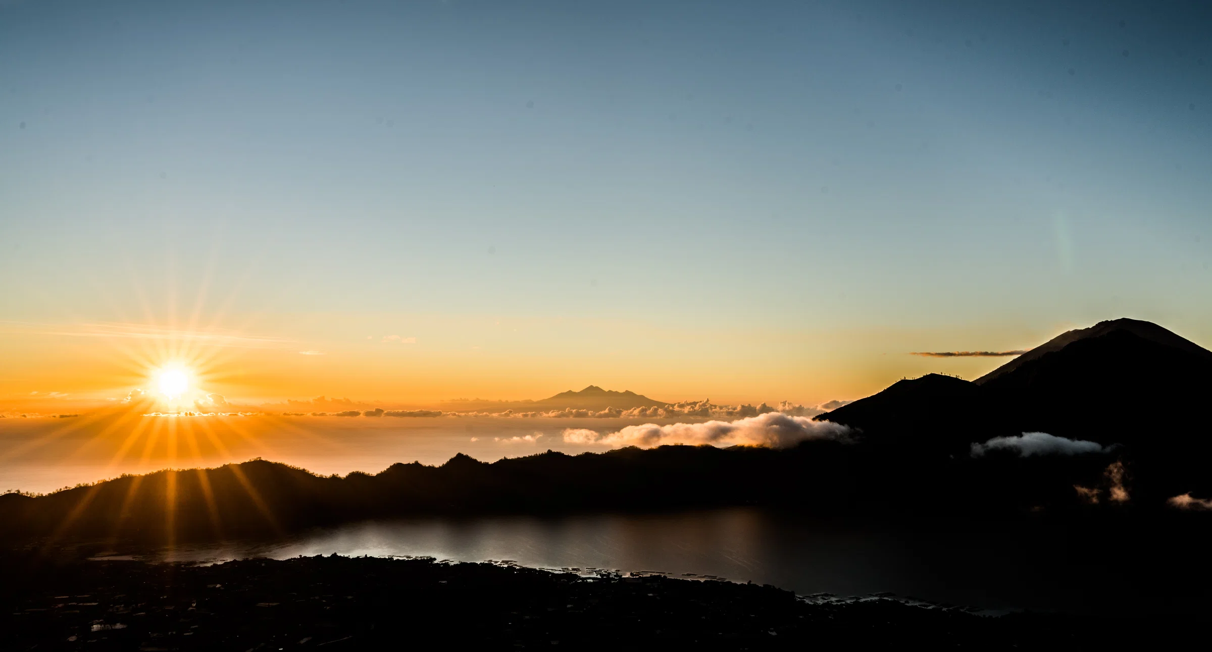 Sunrise from the summit of Mount Batur over Lake Batur, with Mount Agung on the right