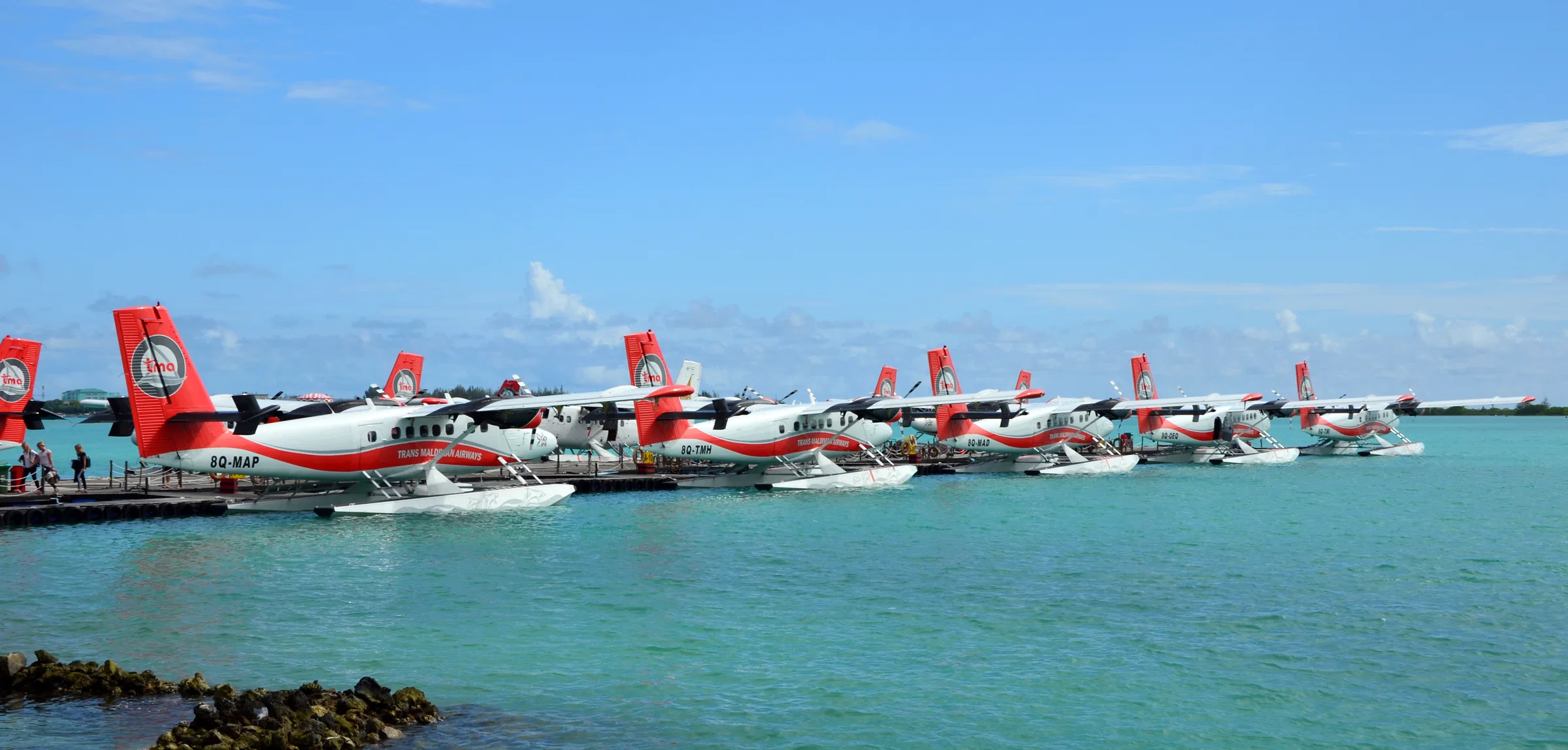 A row of Twin Otter seaplanes moored at the seaplane terminal in Malé