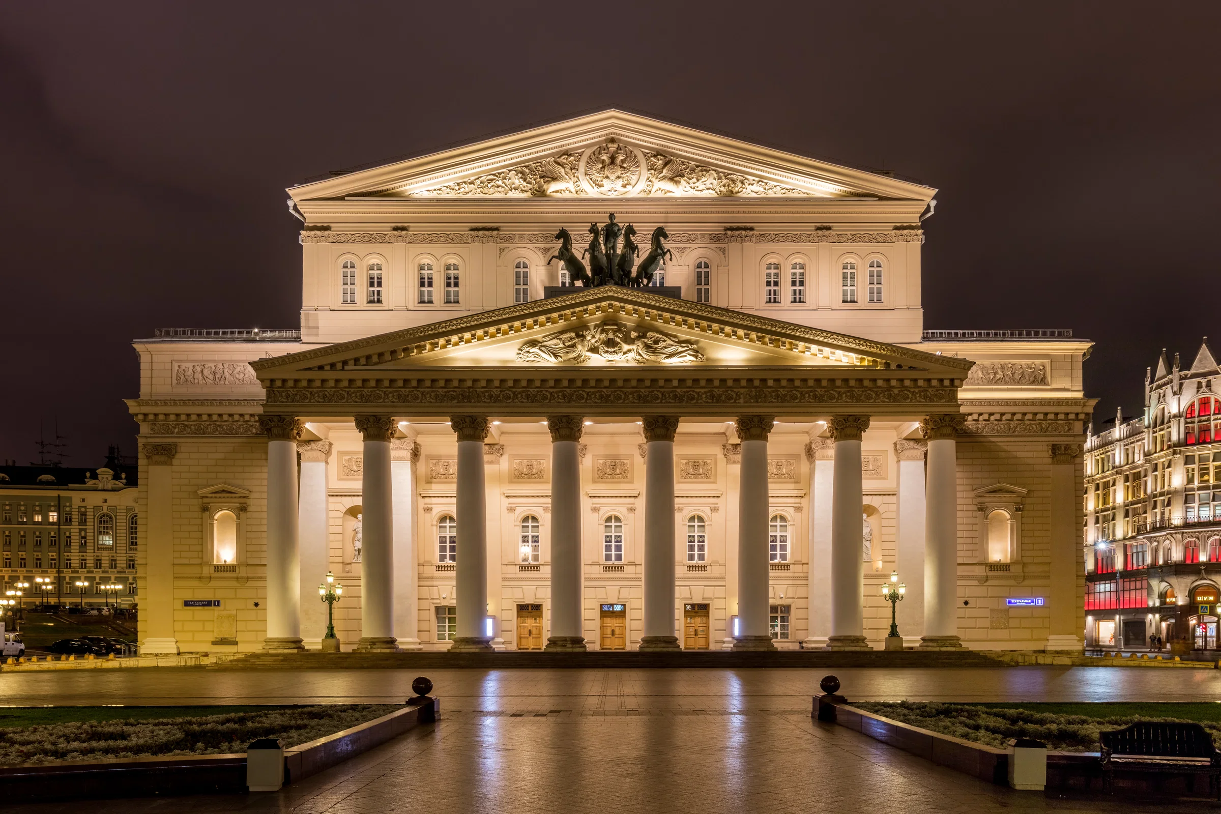 The colonnaded facade of the Bolshoi Theatre in Moscow, lit at dusk