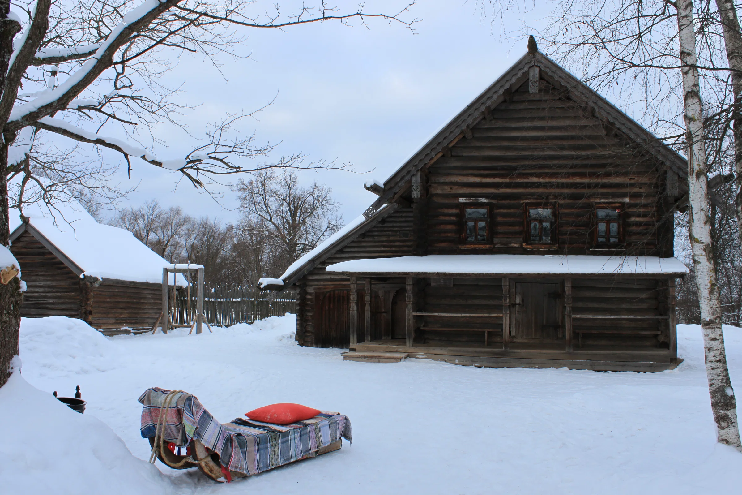 A traditional wooden log house under deep snow at the Vitoslavlitsy museum of wooden architecture, Veliky Novgorod