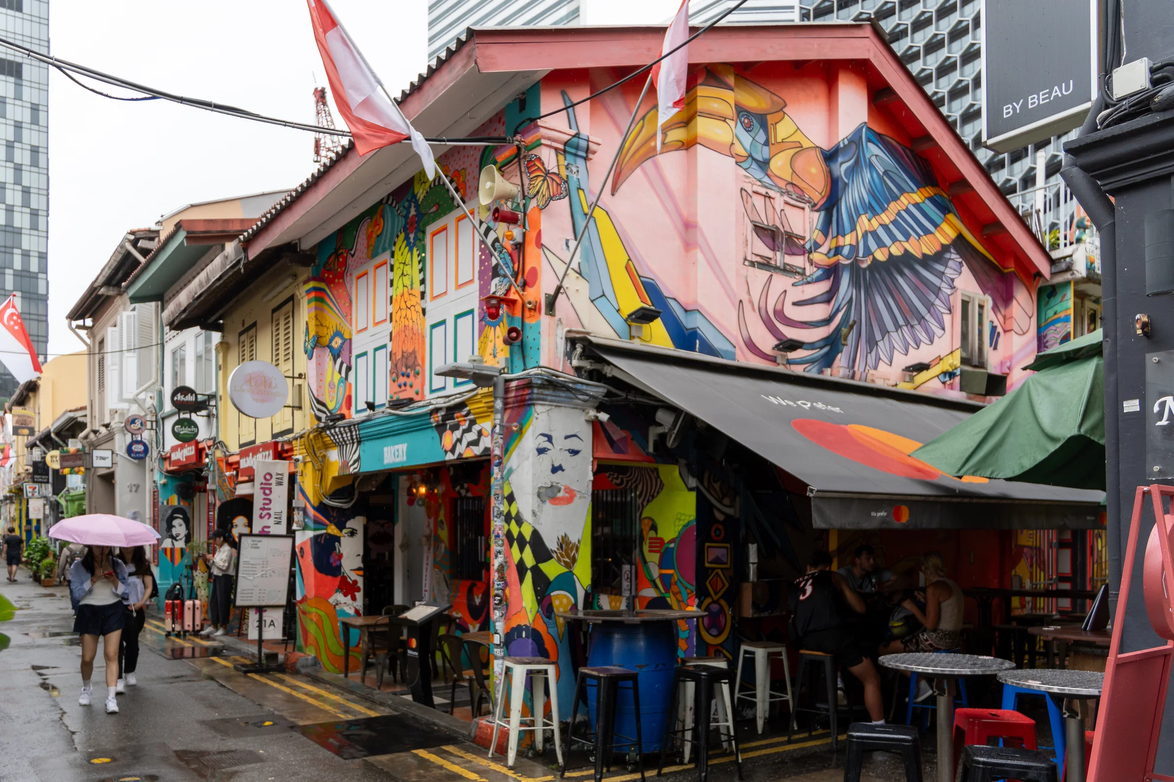 Painted shophouses with large murals and café awnings on Haji Lane, Kampong Glam