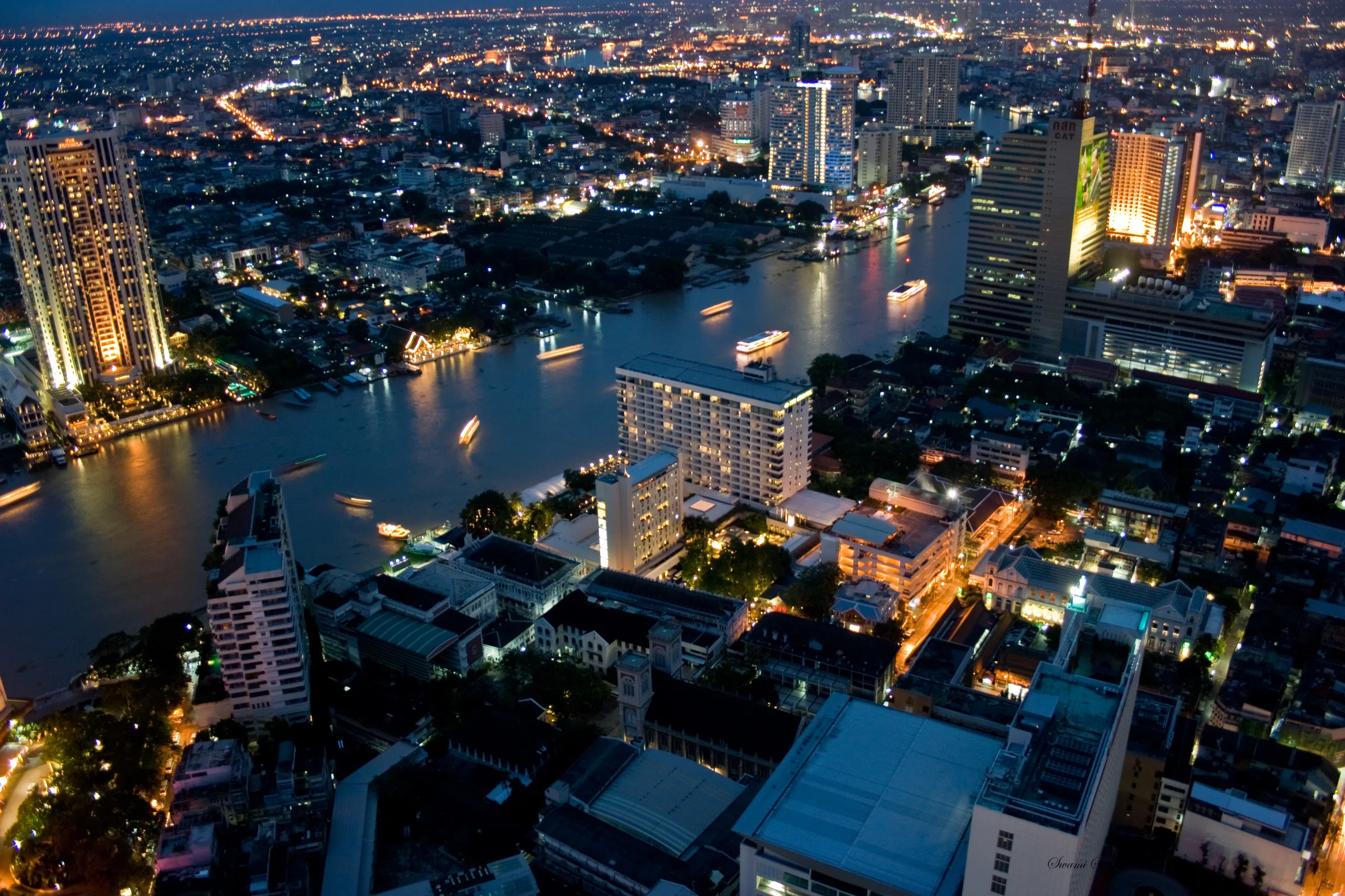 Bangkok at dusk from State Tower, with lit boats on the Chao Phraya River