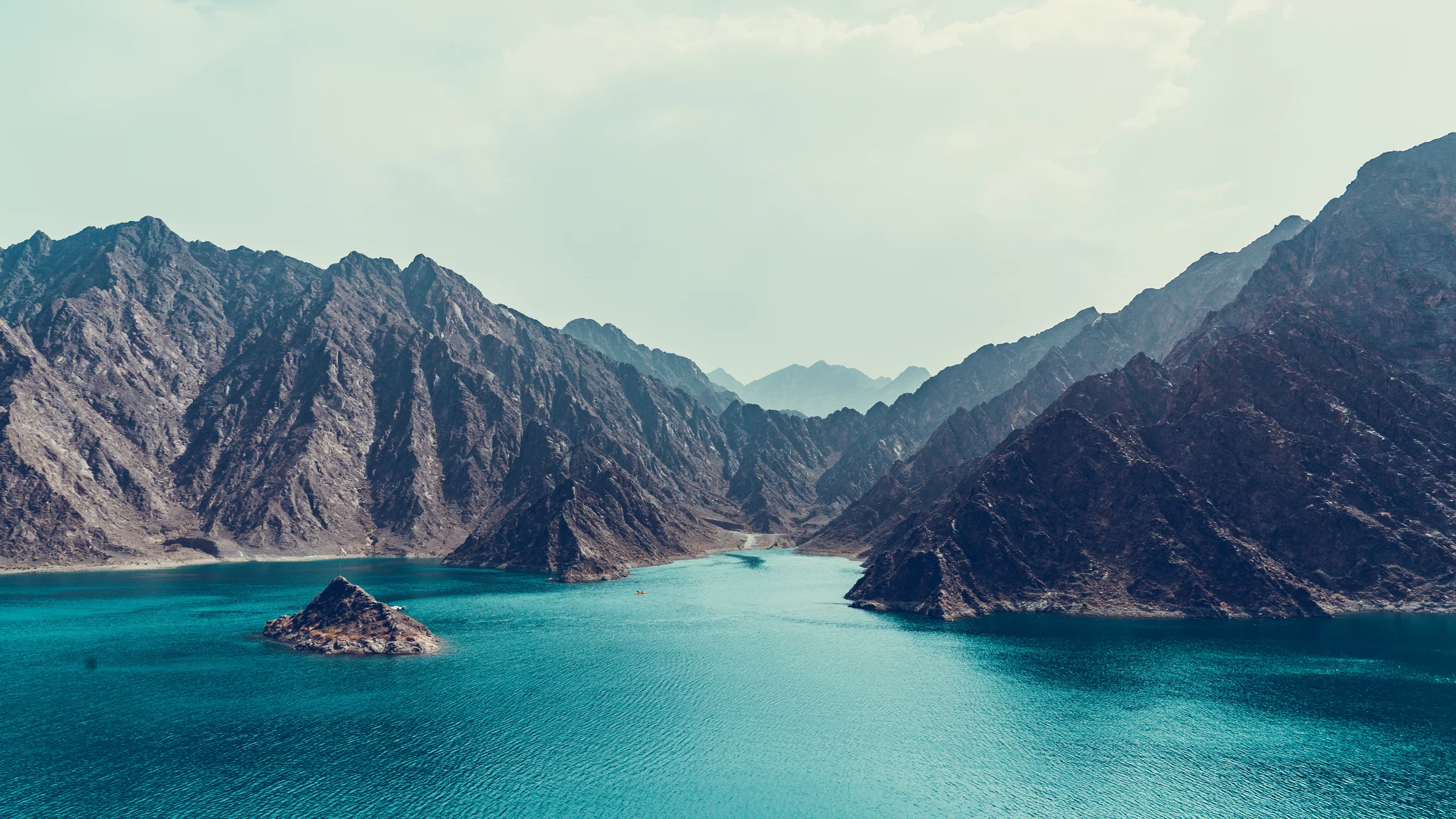 The turquoise lake of Hatta Dam between the Hajar Mountains