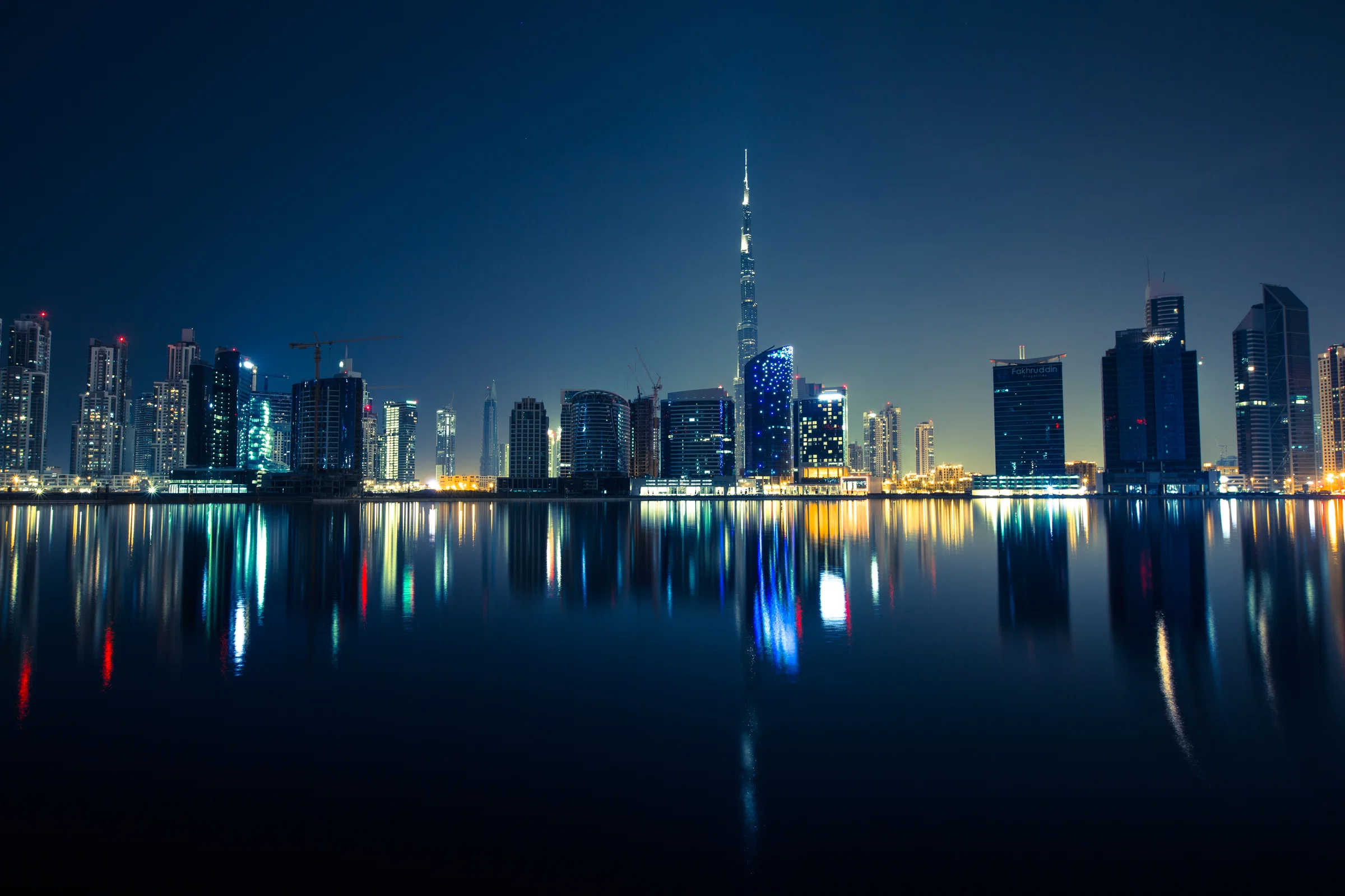The Dubai skyline and Burj Khalifa at night, reflected in still water