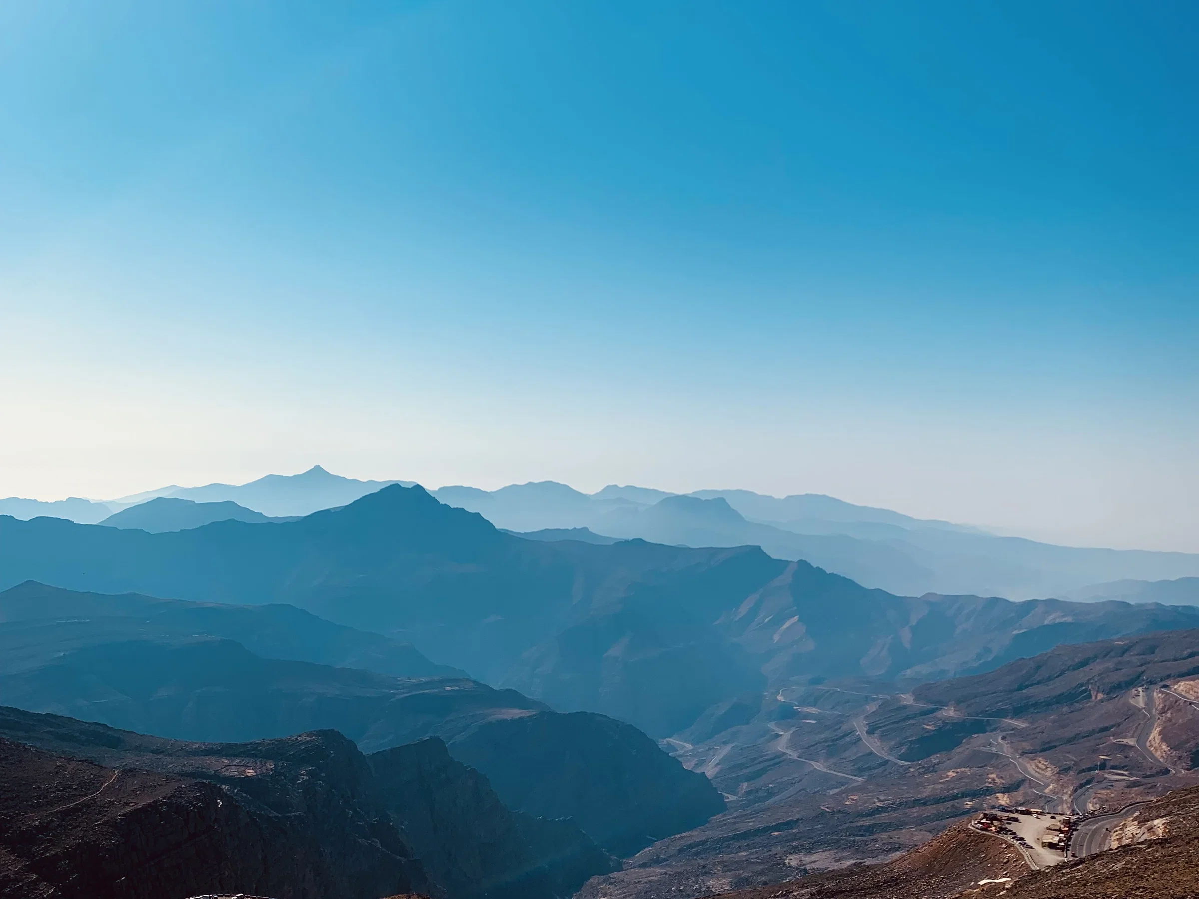 Layered blue ridges of the Hajar Mountains seen from Jebel Jais