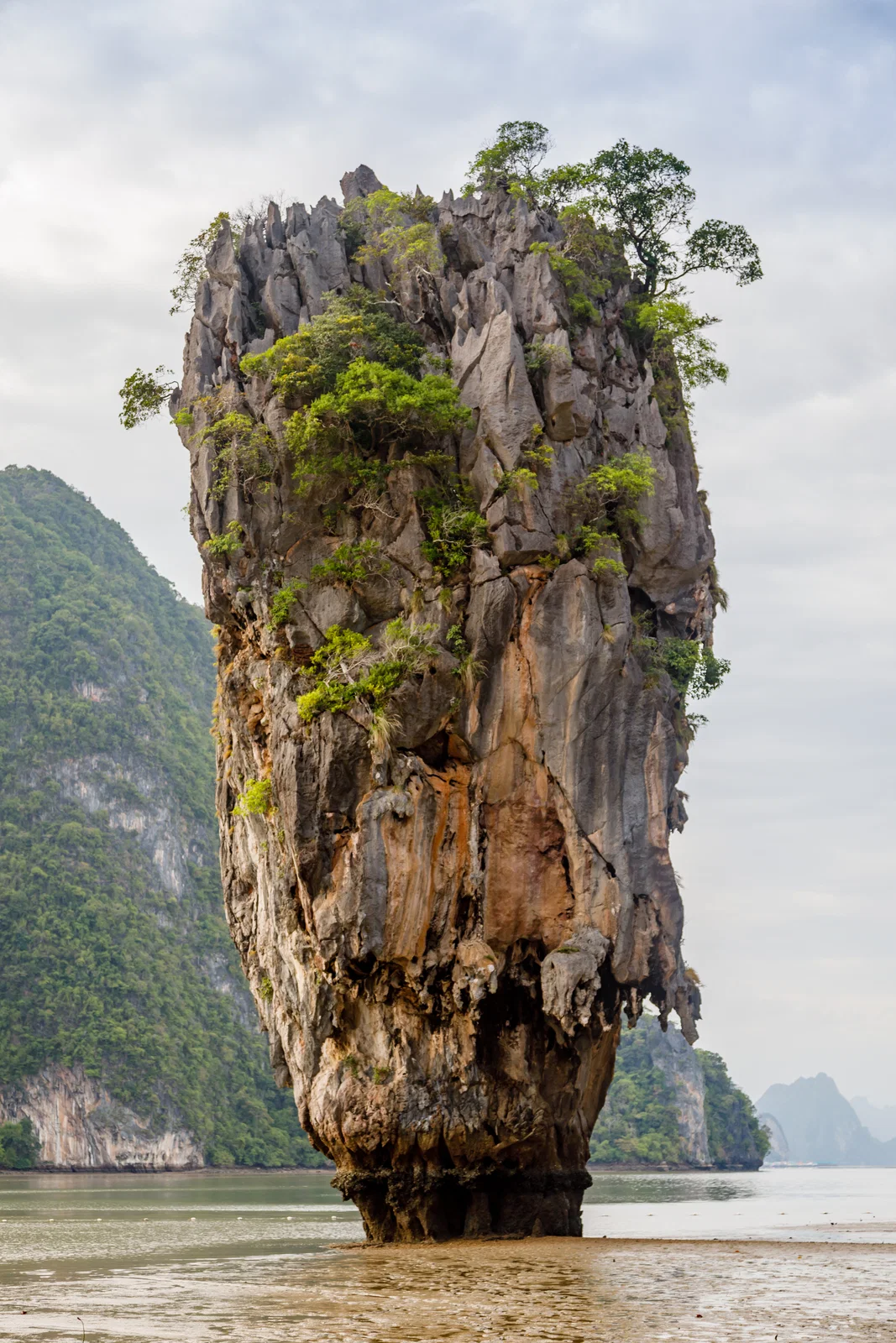 Long-tail boat in the turquoise water below the limestone cliffs of Ko Phi Phi Le