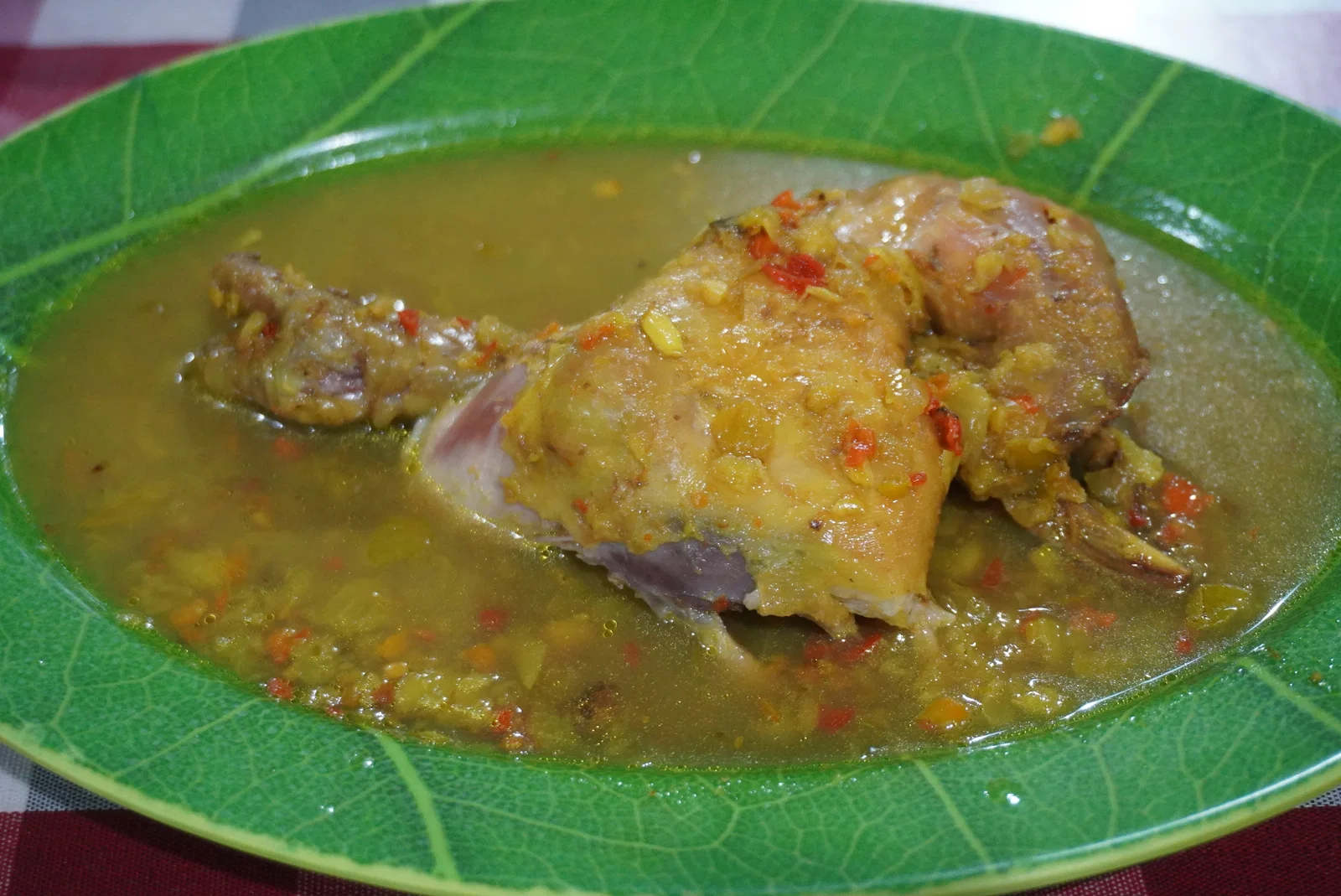 Gilimanuk-style ayam betutu, chicken in a spiced yellow broth, served on a leaf-shaped plate