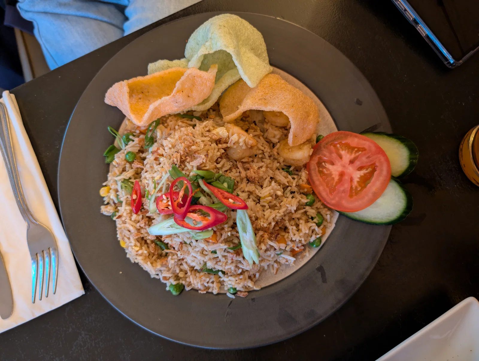 A plate of nasi goreng with prawns, krupuk crackers, chilli and tomato, served in Bali