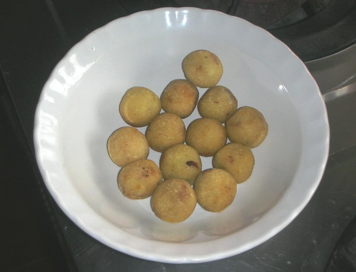 A bowl of gulha, small fried dumplings filled with tuna and coconut