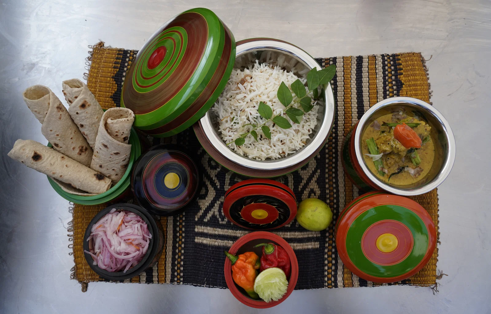 Kandu kukulhu tuna curry served with roshi, rice, onion and chillies in traditional lacquered boxes