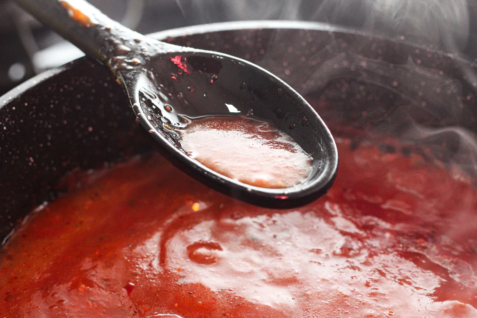 A tomato sauce simmering in a pan, the base of a rougaille