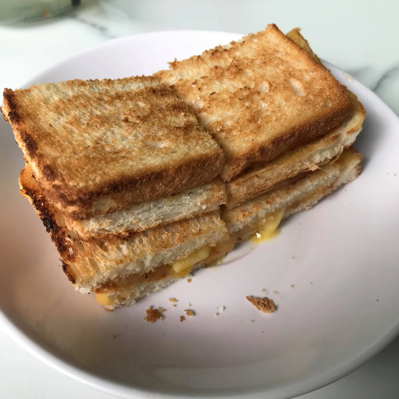 Toasted kaya and butter sandwiches stacked on a white plate