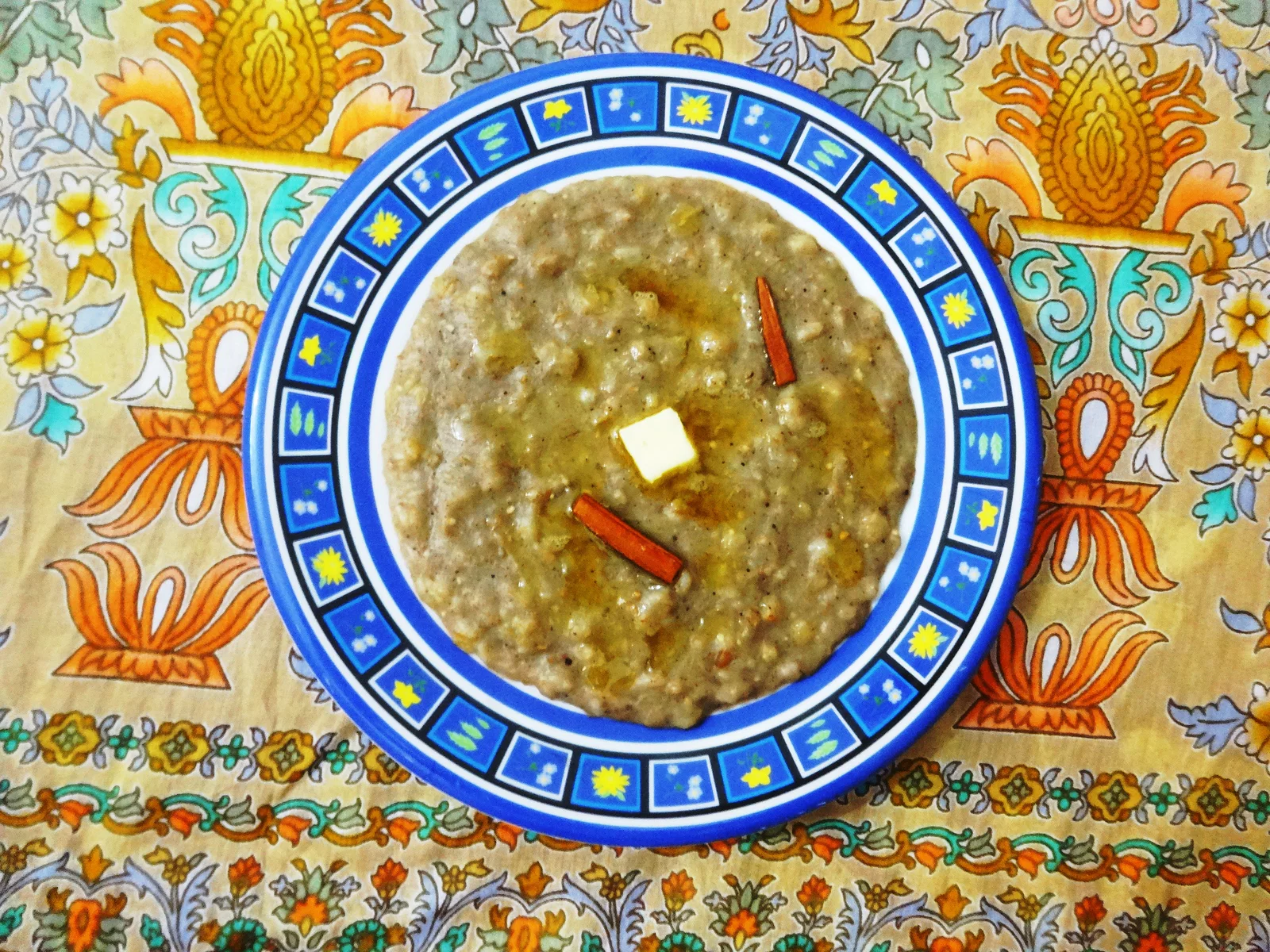 A plate of harees topped with ghee and cinnamon