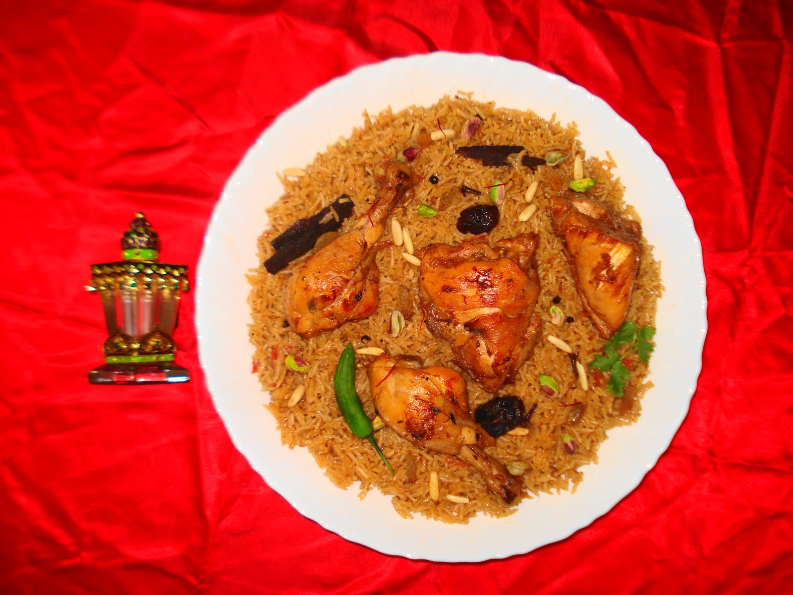 Chicken machboos on spiced rice served on a white plate