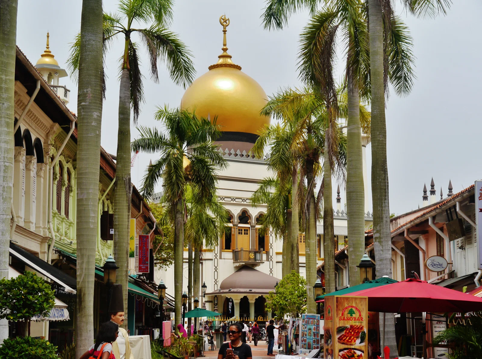 The golden dome of the Sultan Mosque rising beyond the palms and shophouses of Bussorah Street