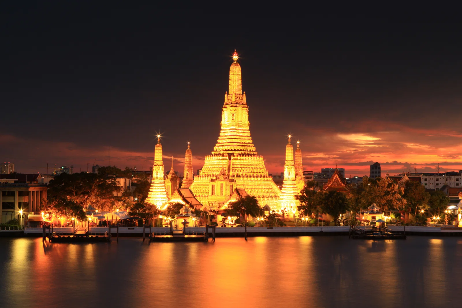 Wat Arun lit at night across the Chao Phraya River, Bangkok
