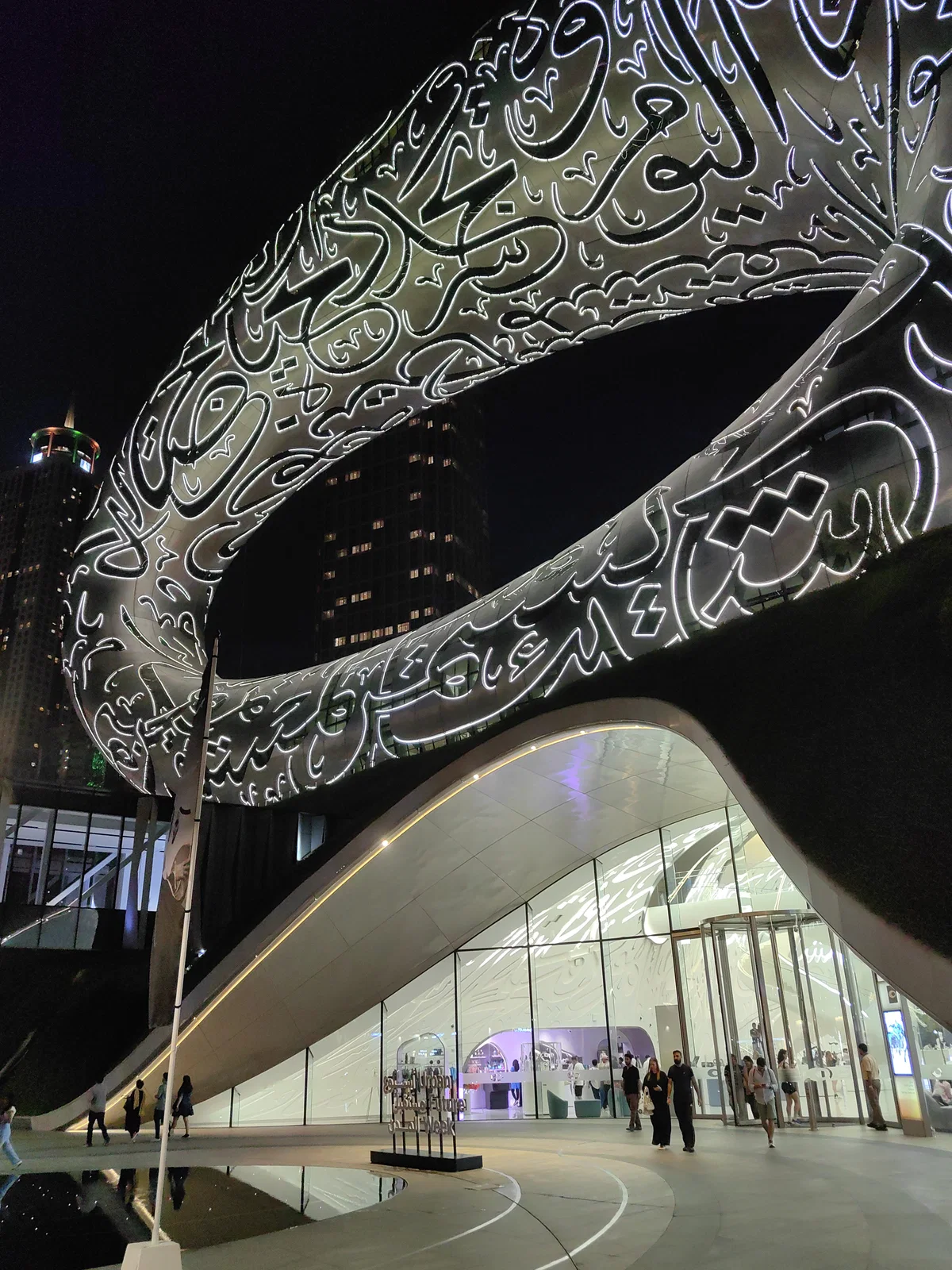 The Museum of the Future at night, its steel ring lit through Arabic calligraphy
